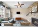 Bright living room boasts a stone fireplace, ceiling fan, large windows, and comfortable seating at 12704 Leyden St # D, Thornton, CO 80602