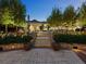 Beautiful backyard with stone steps leading up to a lush garden with manicured landscaping and mature trees at 5 Mockingbird Ln, Cherry Hills Village, CO 80113