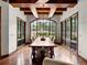 Elegant dining room with a large window offering views of the lush greenery outside and a grand table at 5 Mockingbird Ln, Cherry Hills Village, CO 80113