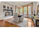 Cozy dining room with fireplace, chandelier, and large windows with views of the outdoors at 5 Mockingbird Ln, Cherry Hills Village, CO 80113