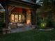Cozy outdoor patio with a stone fireplace, comfortable seating, and lush landscaping at 5 Mockingbird Ln, Cherry Hills Village, CO 80113
