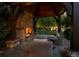 Outdoor living space features stone fireplace, wood beam archways, and seating at 5 Mockingbird Ln, Cherry Hills Village, CO 80113