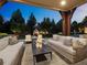 Inviting outdoor patio with ample seating, a fireplace, and manicured landscaping, perfect for entertaining at 5 Mockingbird Ln, Cherry Hills Village, CO 80113