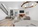 Open-concept living room with brick fireplace, modern lighting, and adjacent staircase at 1981 S Hannibal Ct # B, Aurora, CO 80013