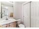 Well-lit bathroom featuring a vanity with a sink, toilet and a mirrored cabinet at 1469 S Ulster St, Denver, CO 80231