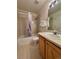 Bathroom featuring a tub/shower, toilet, vanity with single sink and wood cabinets at 1469 S Ulster St, Denver, CO 80231