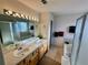 Well-lit bathroom featuring a double sink vanity, bathtub, and a shower at 1469 S Ulster St, Denver, CO 80231