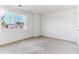 An empty, light-filled bedroom with neutral carpet and a large window overlooking the neighborhood at 1469 S Ulster St, Denver, CO 80231