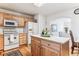 Bright kitchen featuring natural wood cabinets, center island, and stainless steel appliances at 1469 S Ulster St, Denver, CO 80231