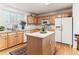 Bright kitchen featuring natural wood cabinets, center island, and stainless steel appliances at 1469 S Ulster St, Denver, CO 80231