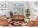 Bright living room featuring large windows, vaulted ceiling, and cozy leather seating at 1469 S Ulster St, Denver, CO 80231