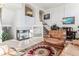 Open-concept living room with fireplace, staircase, and cozy seating area with a leather recliner at 1469 S Ulster St, Denver, CO 80231