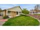 Well-maintained lawn with a patio, wooden trellis, and beautiful landscaping at 3930 Miller St, Wheat Ridge, CO 80033