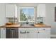 Modern kitchen featuring stainless steel appliances, white cabinets, and a stylish backsplash at 3930 Miller St, Wheat Ridge, CO 80033