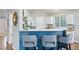 Bright kitchen featuring a breakfast bar with seating, white cabinets, and stainless steel appliances at 3930 Miller St, Wheat Ridge, CO 80033