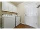 Functional laundry room with white cabinets, washer, dryer, and an exterior door at 3930 Miller St, Wheat Ridge, CO 80033