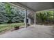 Covered back patio leads to a lush, green yard with mature trees and a storage shed at 523 E Long Ct, Littleton, CO 80122