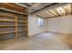 Unfinished basement with a window for natural light and additional storage on built-in shelving at 523 E Long Ct, Littleton, CO 80122
