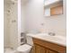 Bathroom features a shower, toilet, sink, and storage shelving for a clean look at 523 E Long Ct, Littleton, CO 80122