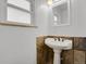Bathroom with a pedestal sink and tiled backsplash at 440 Balsam St, Lakewood, CO 80226