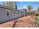 Back of house showing a patio with brickwork, a building with gray siding, and a natural wood-sided room addition at 440 Balsam St, Lakewood, CO 80226