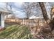 Side yard with mature trees, lawn, and wooden fence at 9393 W 14Th Ave, Lakewood, CO 80215