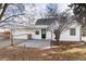 White farmhouse style home with concrete patio and landscaping at 9393 W 14Th Ave, Lakewood, CO 80215