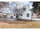 White farmhouse style home with a gray roof and landscaping at 9393 W 14Th Ave, Lakewood, CO 80215