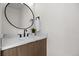 Bathroom features a stylish vanity with round mirror and modern fixtures at 1747 Lowell Blvd, Denver, CO 80204