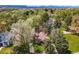 An aerial view of the property shows mature trees, blue skies, and surrounding area at 1051 Independence St, Lakewood, CO 80215