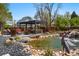 Backyard oasis featuring a pond with waterfall, a gazebo and outdoor seating with mature landscaping at 1051 Independence St, Lakewood, CO 80215