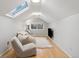 Bright bonus room with skylight, hardwood floors, and comfortable seating area at 1051 Independence St, Lakewood, CO 80215
