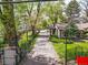 Gated driveway leading to a charming home with mature trees and landscaping, offering privacy and curb appeal at 1051 Independence St, Lakewood, CO 80215