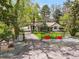 Charming home with a gated driveway, lush landscaping, and red flowerpots adding a splash of color at 1051 Independence St, Lakewood, CO 80215