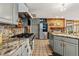 Spacious kitchen featuring stainless steel appliances, granite countertops, and a brick fireplace at 1051 Independence St, Lakewood, CO 80215