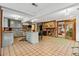 Open-concept kitchen with island, stainless appliances, brick fireplace, and abundant natural light at 1051 Independence St, Lakewood, CO 80215