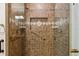 Up-close view of the tiled shower featuring glass door and bronze fixtures at 1051 Independence St, Lakewood, CO 80215
