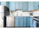 Modern kitchen featuring blue cabinets, white countertops, and stainless steel appliances at 800 Washington St # 302, Denver, CO 80203