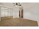 Spacious bedroom featuring neutral carpet and walls, a mirrored closet, and a ceiling fan at 1520 Phillips Dr, Northglenn, CO 80233