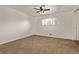 Spacious bedroom featuring neutral carpet and walls, a ceiling fan, and a window for natural light at 1520 Phillips Dr, Northglenn, CO 80233