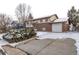 Inviting two-story house with brick and siding exterior, attached garage, and snow-covered front yard on a winter day at 1520 Phillips Dr, Northglenn, CO 80233