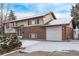 Inviting two-story home with brick and siding, featuring an attached garage and a snow-covered driveway and lawn at 1520 Phillips Dr, Northglenn, CO 80233