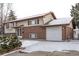 Charming two-story home featuring a brick facade, attached garage, and snow-covered driveway in a suburban neighborhood at 1520 Phillips Dr, Northglenn, CO 80233