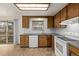 Well-lit kitchen with wood cabinetry, neutral countertops, white appliances, and a view to the deck through sliding doors at 1520 Phillips Dr, Northglenn, CO 80233