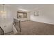 Spacious carpeted living room with a large bay window, chandelier, and staircase in a well-lit, modern home at 1520 Phillips Dr, Northglenn, CO 80233