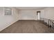 Simple living area with plush carpeting, neutral walls, and a view towards the kitchen and staircase at 1520 Phillips Dr, Northglenn, CO 80233