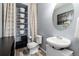 Powder room with chrome fixtures, wooden look floors, and stacked white shelves and cabinet at 4797 Flower St, Wheat Ridge, CO 80033