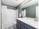 Bathroom features white tile, gray vanity, double sinks, and shower with tub at 4797 Flower St, Wheat Ridge, CO 80033