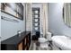 Powder room with chrome fixtures, wooden look floors, and stacked white shelves and cabinet at 4797 Flower St, Wheat Ridge, CO 80033
