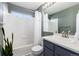 Bright bathroom featuring a shower-tub combo, modern vanity, and stylish white tiling for a clean, fresh look at 4797 Flower St, Wheat Ridge, CO 80033
